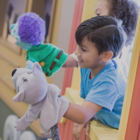 Young boy playing with puppets