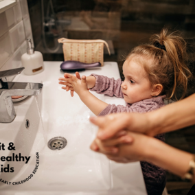 Young girl washing her hands by the sink