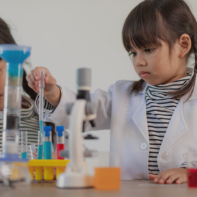 Young girl mixing test tubes