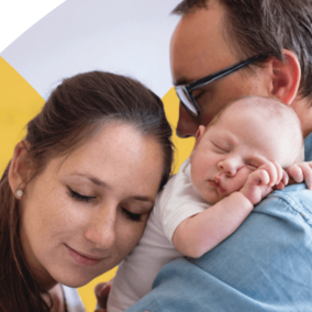 Baby held by two caregivers