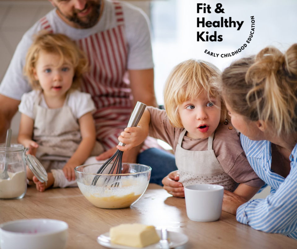 Two children with two adults in aprons cooking