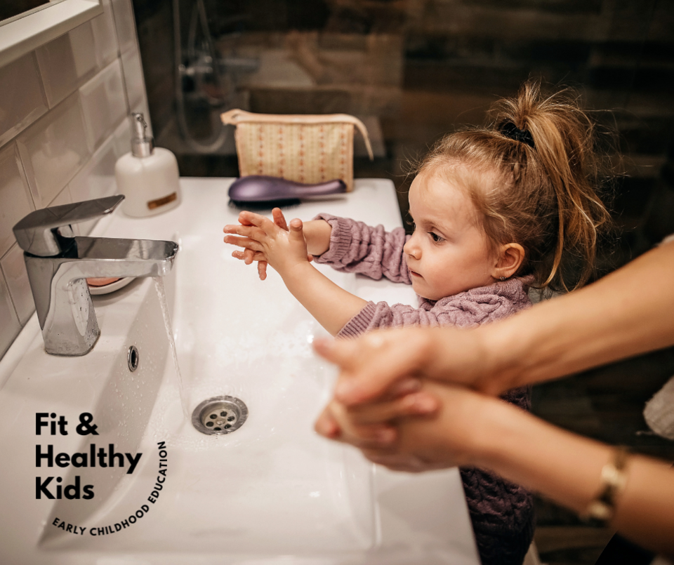 Young girl washing her hands by the sink