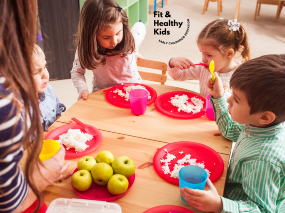 Four children sitting around table eating