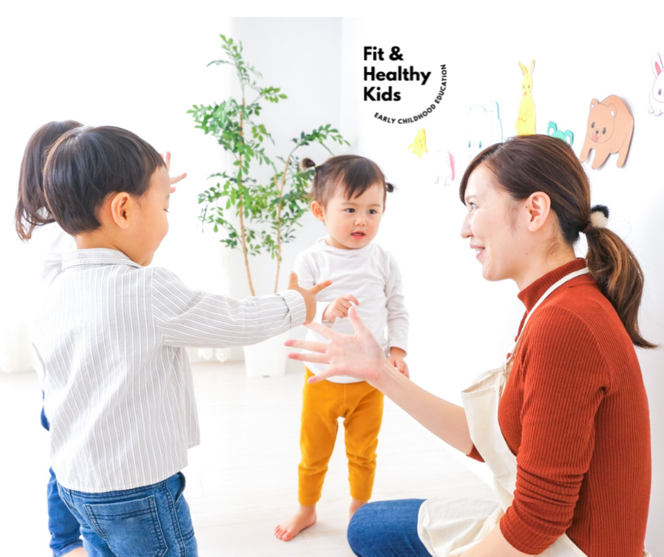 Teacher knelt down talking with three children